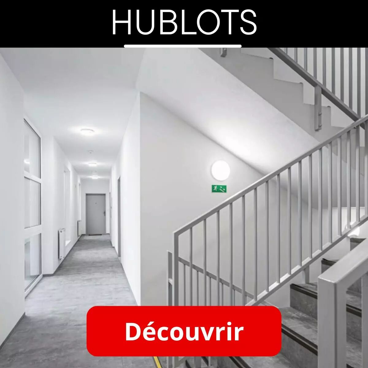 Dans un environnement o� se confondent gris et blanc, d�bouchant sur un long couloir, un hublot se dessine de sa silhouette lumineuse dans un escalier, au-dessus d'une sortie de secours.