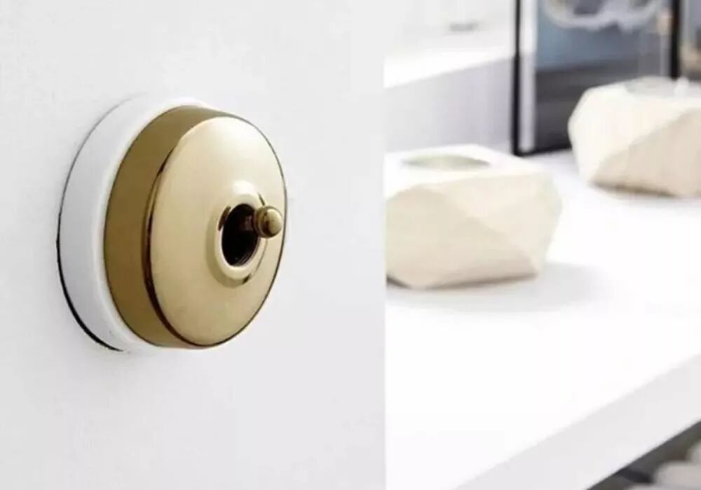interrupteur r�tro en laiton finition dor�e avec plaque en porcelaine blanche dans int�rieur minimaliste