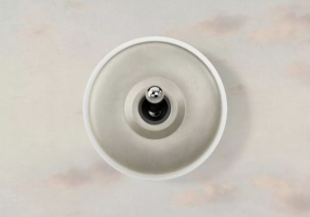 Installation en saillie d'un interrupteur � base porcelaine blanche et d�me et levier chrom�s. Le mur est gris avec de l�g�res touches de rose pastel en forme de nuages.