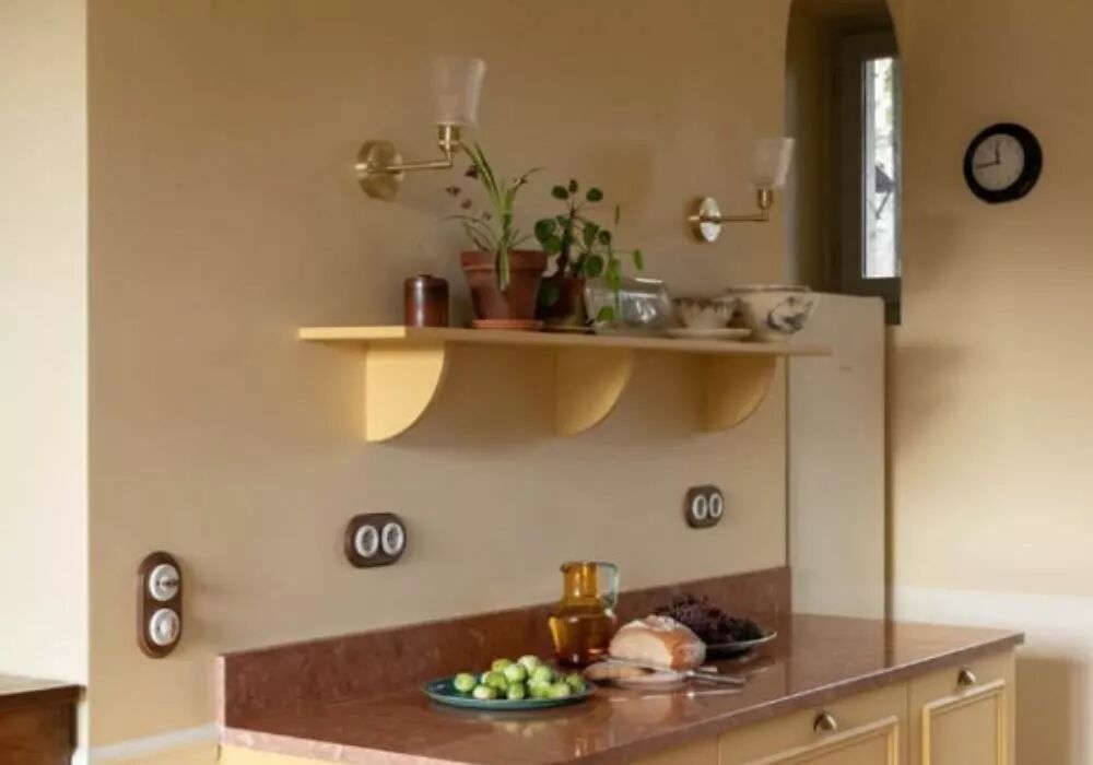 Plac�s entre un buffet et une �tag�re, trois plaques doubles en bois de h�tre accueillent des appareillages en porcelaine blanche de la gamme Garby Colonial. Les manettes des interrupteurs sont con�us dans le m�me bois que celui des plaques de finition. 