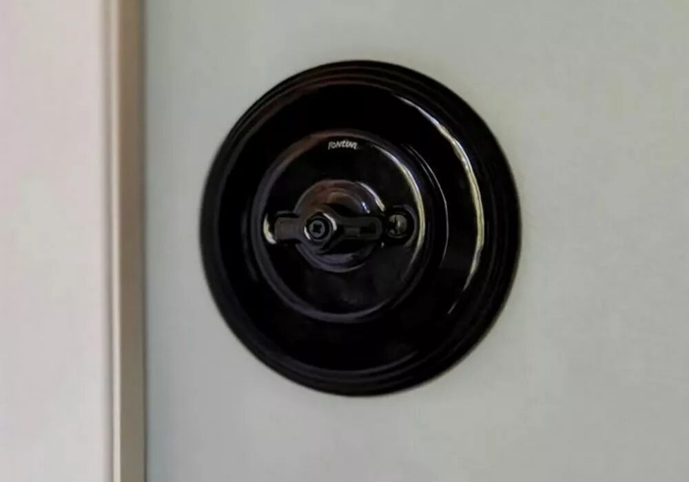 Plaque simple en porcelaine noire de la gamme Garby Colonial avec interrupteur en porcelaine noire � manette rotative.